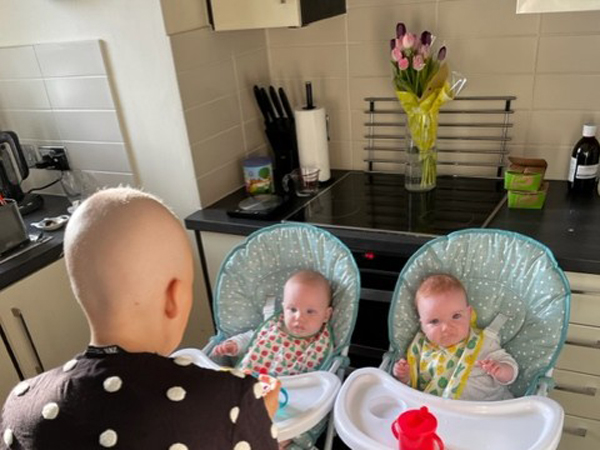 Charlie May with her twins in highchairs 