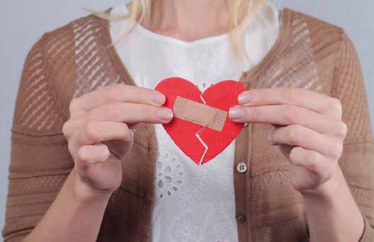 Woman holding a paper broken heart