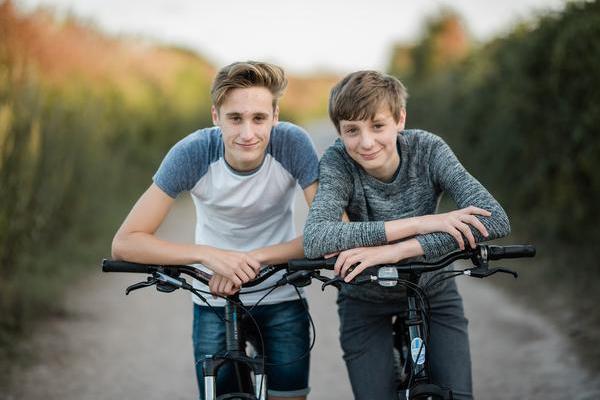 Twin boy teenagers on bikes