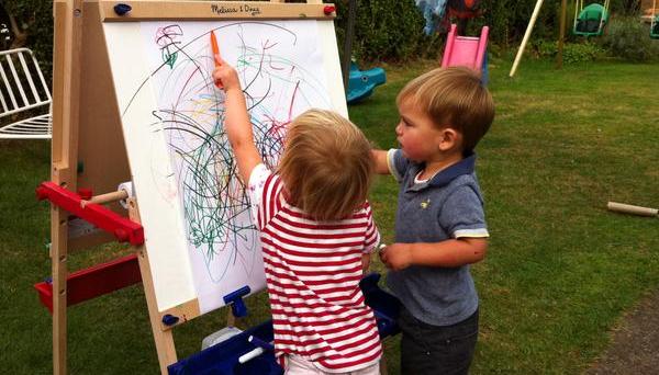 Twins drawing on whiteboard